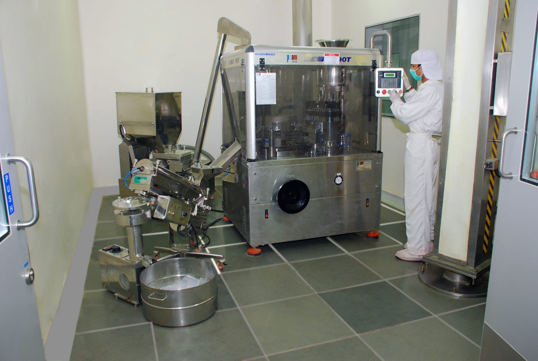 Biodeal DSIR-approved R&D and production — operator running a capsule-filling line in a WHO-GMP cleanroom